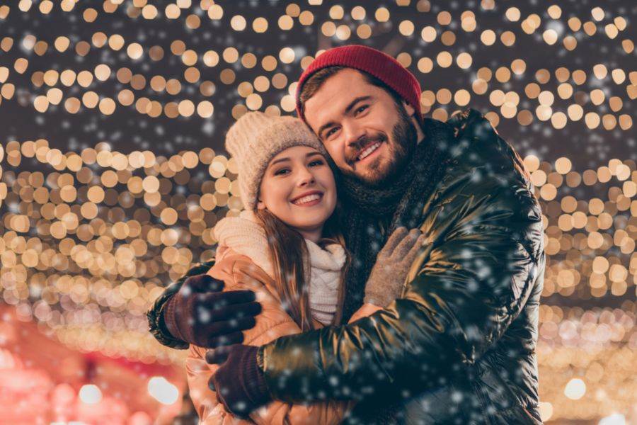 Young couple hugging in festive lights